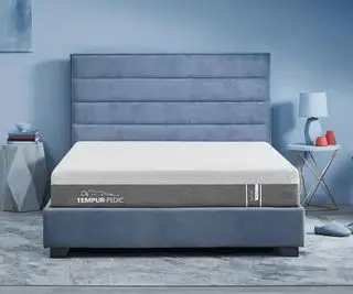 青い壁に映えるテンピュール ペディック プロアダプト マットレス。