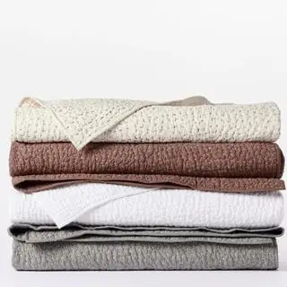 Courtepointe biologique cousue à la main en galets sur fond blanc.