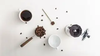 grains de café, une tasse de café, un porte-filtre sur fond blanc du point de vue d'un oiseau