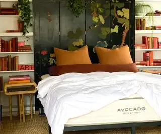 Un materasso verde avocado contro una testiera in legno scuro.