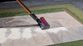 Testen Sie Mehl und Zucker auf Linoleum mit dem Dyson Cyclone V10 Absolute. Es hat eine klare Spur von Mehl und Zucker entfernt