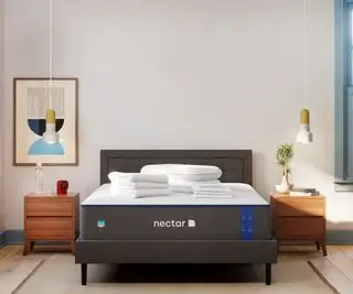 Matelas en mousse à mémoire de forme Nectar contre un mur blanc.