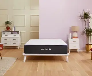 Matelas en mousse à mémoire de forme Nectar contre un mur vert et rose.