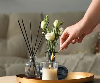 Candela, diffusore e fiori su un tavolo