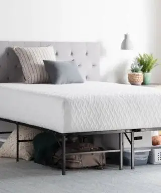 Un cadre de lit avec matelas dessus dans une chambre neutre