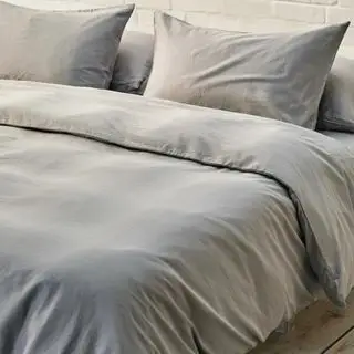 Draps gris sur le lit dans une chambre neutre