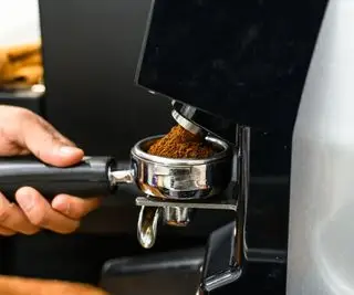 Un moulin à café automatique moulant le café dans un porte-filtre