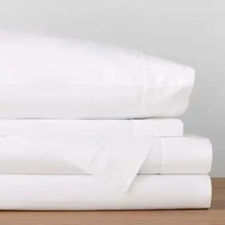 סדין דנפילד כותנה מוצב על קיר אפור.