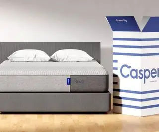 캐스퍼 배송 상자 옆 침대 위에 놓인 캐스퍼 매트리스.