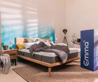 En Emma madras på en seng ved siden af ​​en Emma leveringsboks.