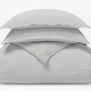 Capa de edredão de linho colocada sobre um fundo branco.