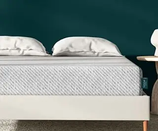 Colchão Leesa Original em uma cama encostada em uma parede verde.