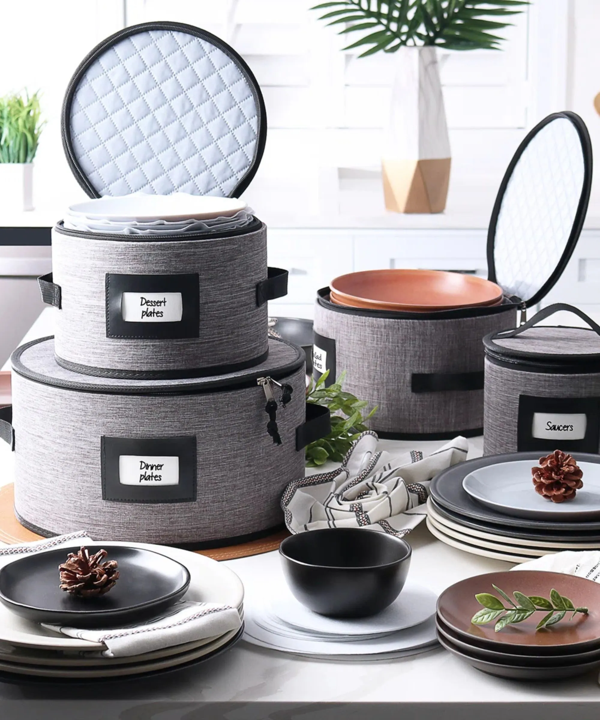 Stosy szarych toreb do przechowywania zastawy stołowej z twardą skorupą, z etykietami otoczonymi naczyniami.' loading='lazy' title=