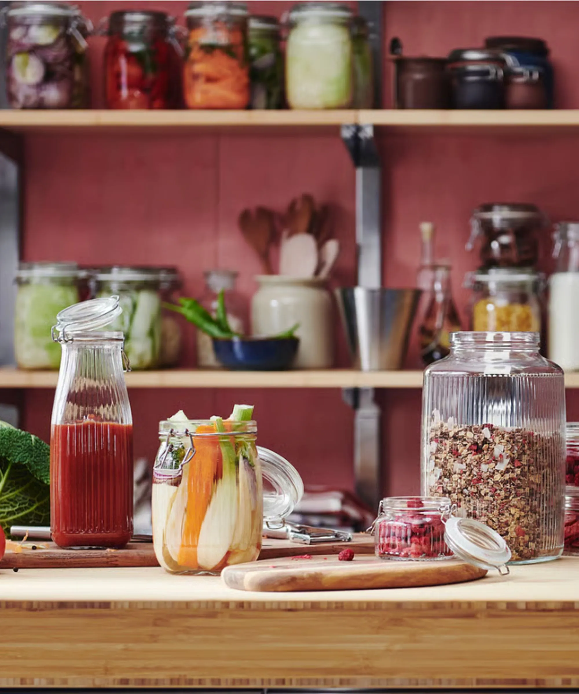 Cocina de color rojo cereza con aparador de madera que exhibe frascos de almacenamiento de alimentos de vidrio estriado' loading='lazy' title=