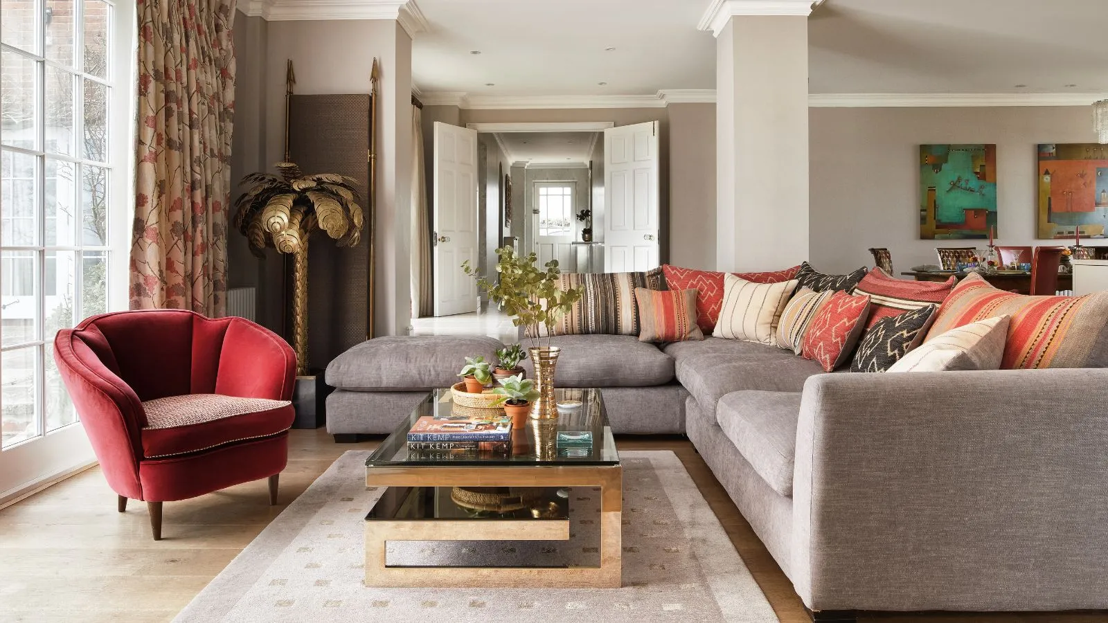 Sala de estar con un gran sofá en forma de L vestido con naranja y hermano' loading='lazy' title=