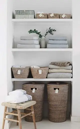 Des solutions de rangement simples mais astucieuses. Couvertures, serviettes et paniers dans le magasin d'alcôve de la chambre.