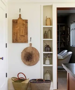 Planches à découper et paniers dans la cuisine avec étagères étroites et parquet