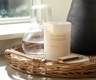 Magnolia lys på en fletbakke med vase og glas