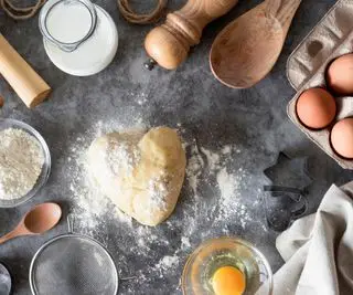 pâte à pâtisserie sur une surface entourée d'ustensiles