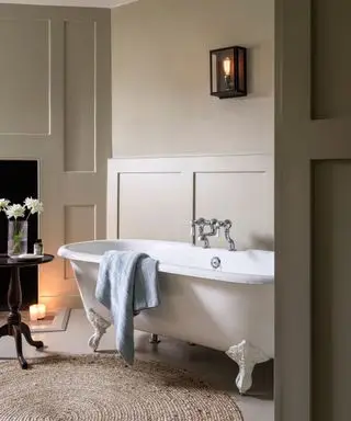 Une salle de bains avec baignoire sur pieds et serviette bleue suspendue sur le côté