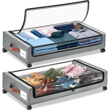 Dois sacos de arrumação em tecido cinzento para debaixo da cama com rodas de plástico pretas e tampas transparentes. Sapatos na bolsa de baixo e camisas dobradas na bolsa de cima.' loading='lazy' title=