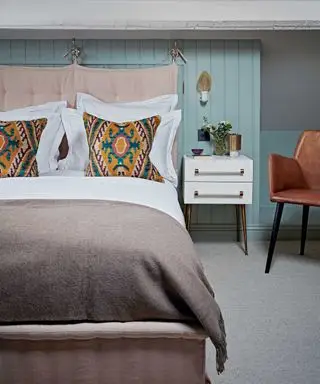 soveværelse med seng, puder og natbord