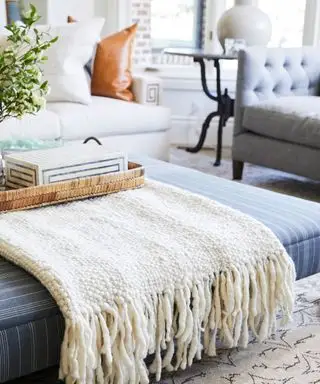 Otomana z kocem w salonie