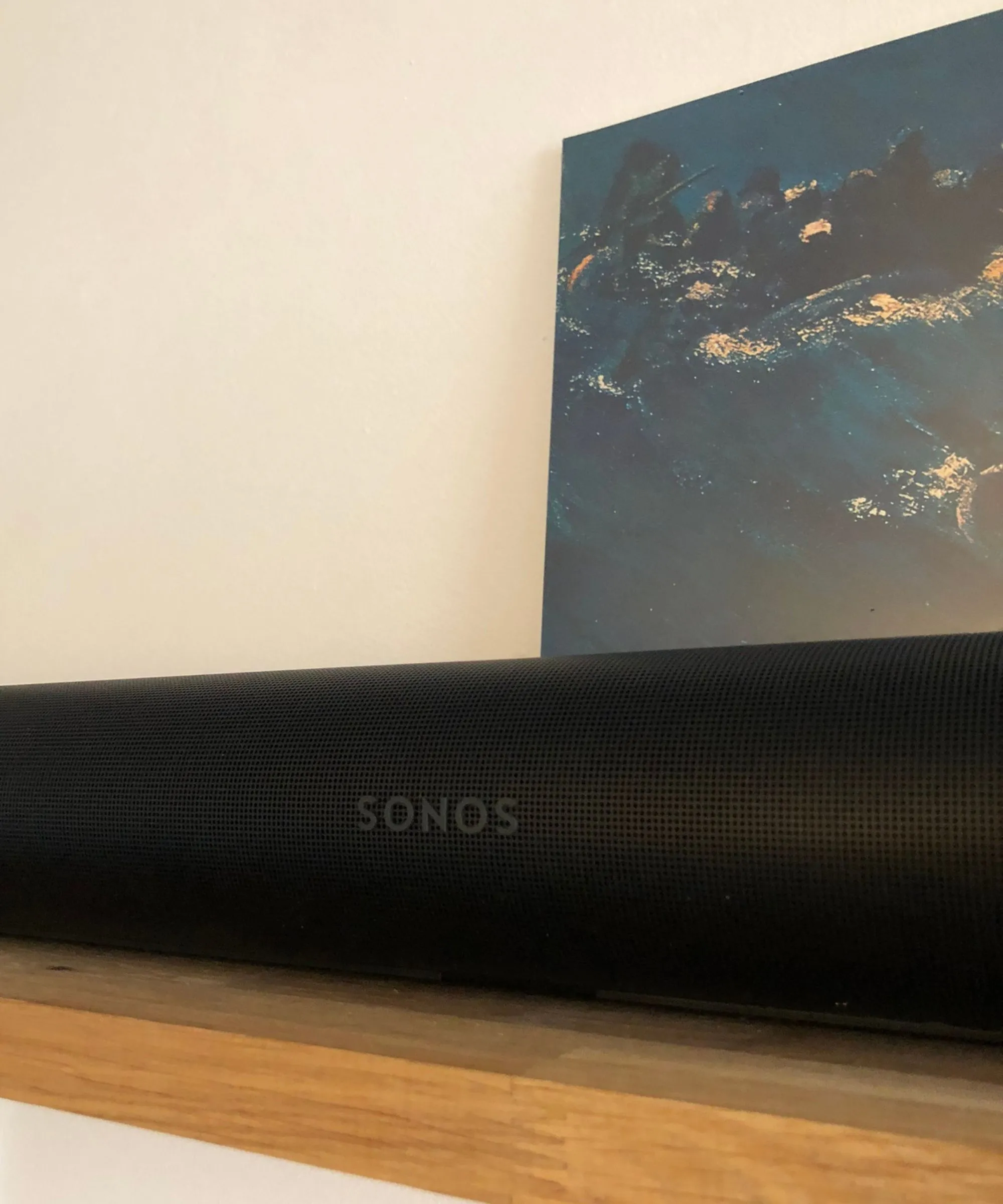Soundbar Sonos Arc Ultra su uno scaffale in legno davanti alla custodia in vinile di Since I Left You degli Avalanches e al muro bianco.' loading='lazy' title=