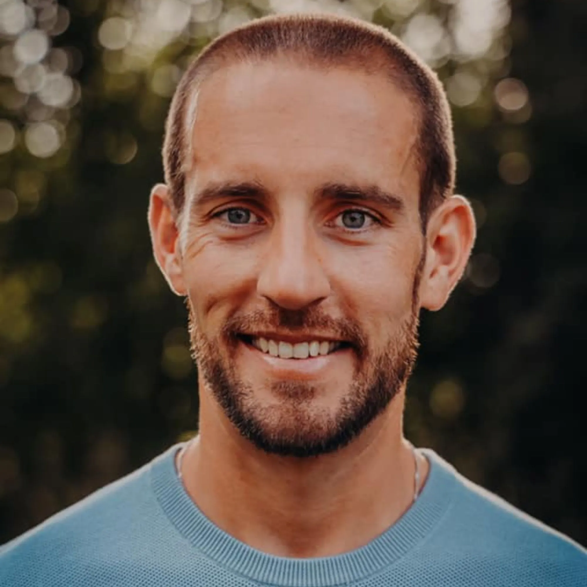 Zdjęcie Scotta Schradera – mężczyzny w niebieskim swetrze uśmiechającego się do kamery' loading='lazy' title=