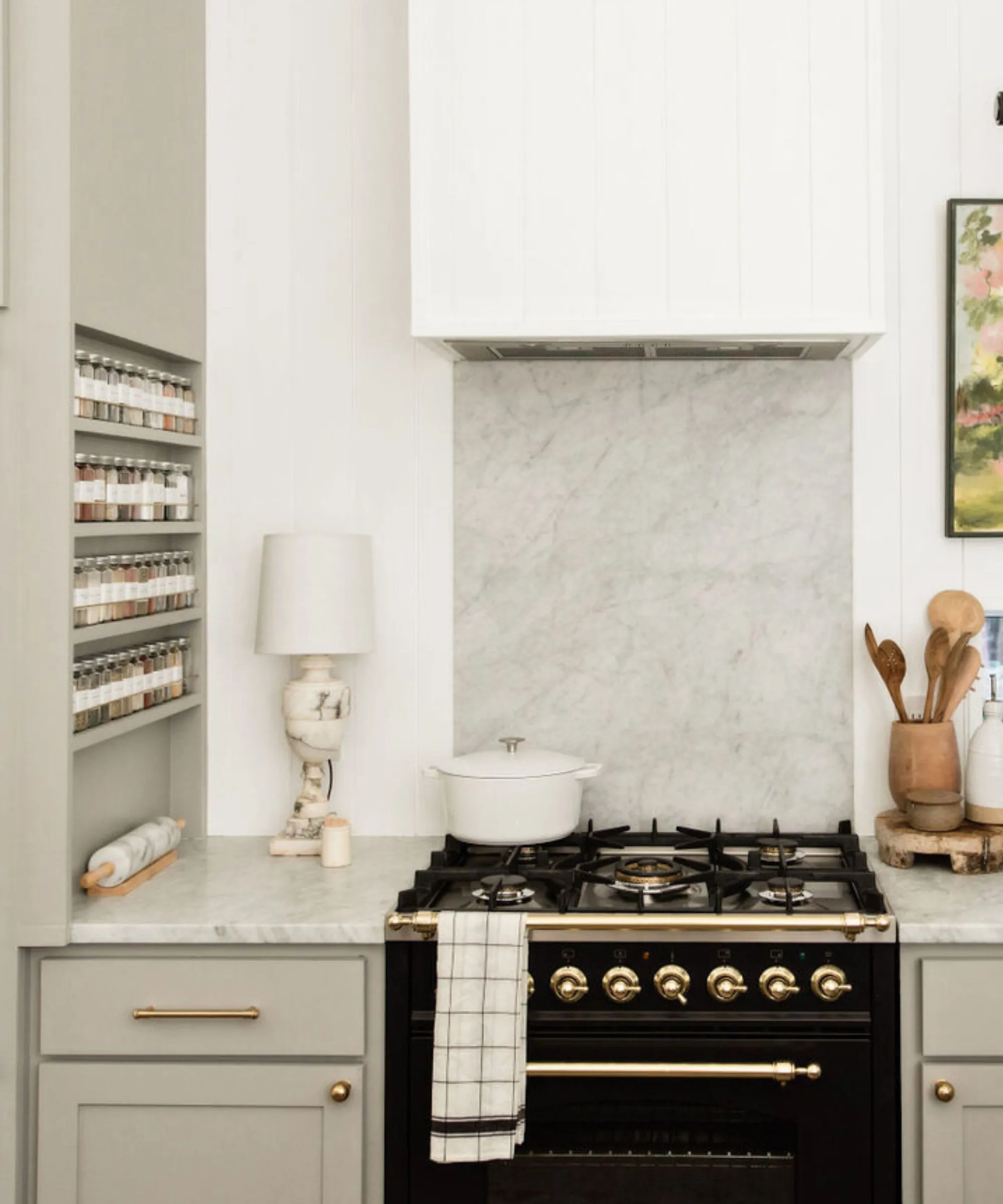 Una cucina bianca con uno spazio rack integrato nel fianco di un pensile' loading='lazy' title=