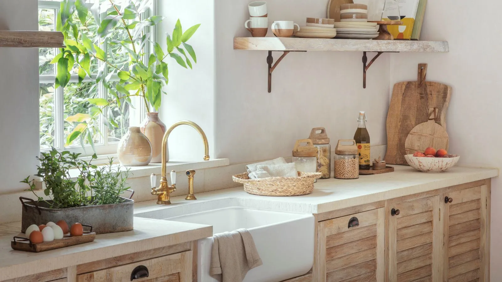 Ein insetiertes Bauernhaus in einer weißen Küchenarbeitsplatte auf hellen Holzschränken.' loading='lazy' title=