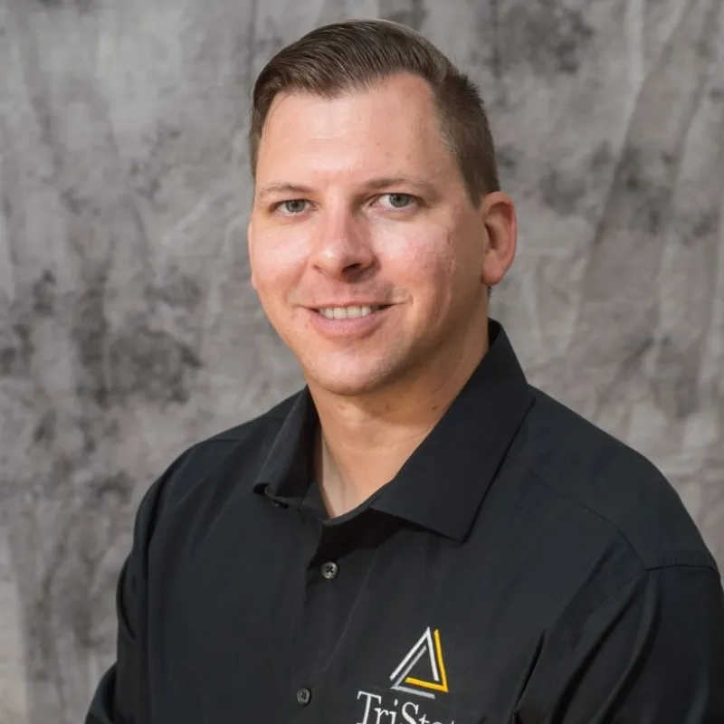 Bert ist ein weißer Mann in einem schwarzen Poloshirt, der in einem Professiona Headshot auf grauem Hintergrund abgebildet ist' loading='lazy' title=