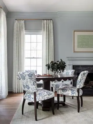 丸いテーブルと椅子、カーテンのある窓のあるリビング ルーム