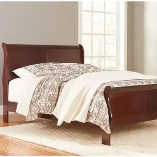 Łóżko w kształcie sań Alisdair z białą pościelą na beżowej ścianie.