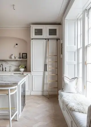 Cucina bianca con ripostiglio dal pavimento al soffitto e scala