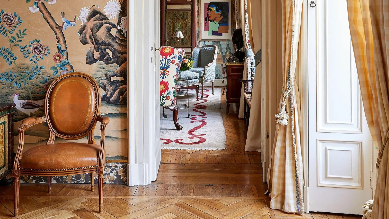 Mehrschichtiger Eingangsbereich mit Holzböden, lebendiger Tapete und Ledersessel' loading='lazy' title=