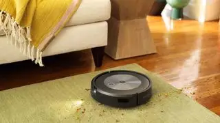 Tapis d'aspiration sous vide iRobot sur parquet, canapé en arrière-plan avec jet jaune